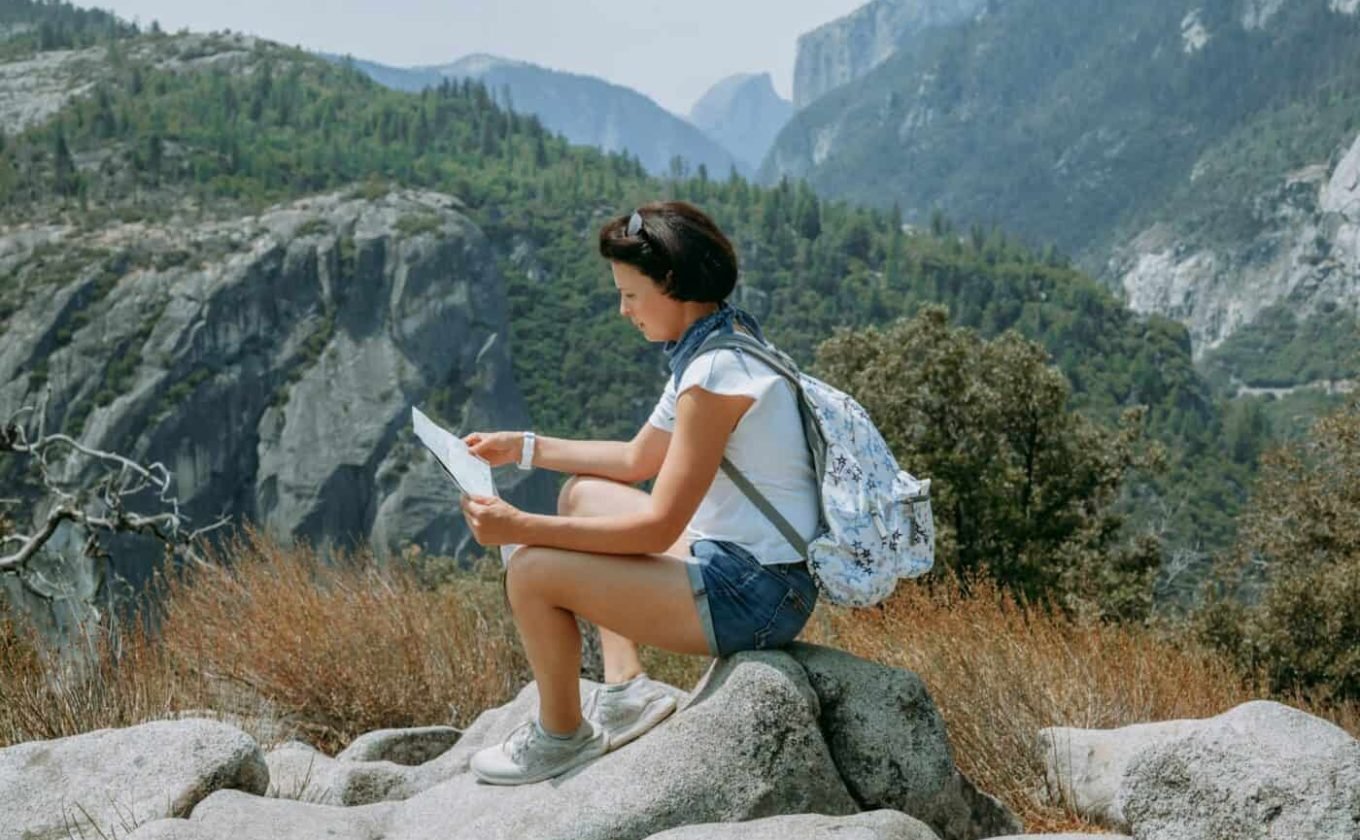 Mountain hike. Woman admiring epic mountains view. Travel and explore concept.